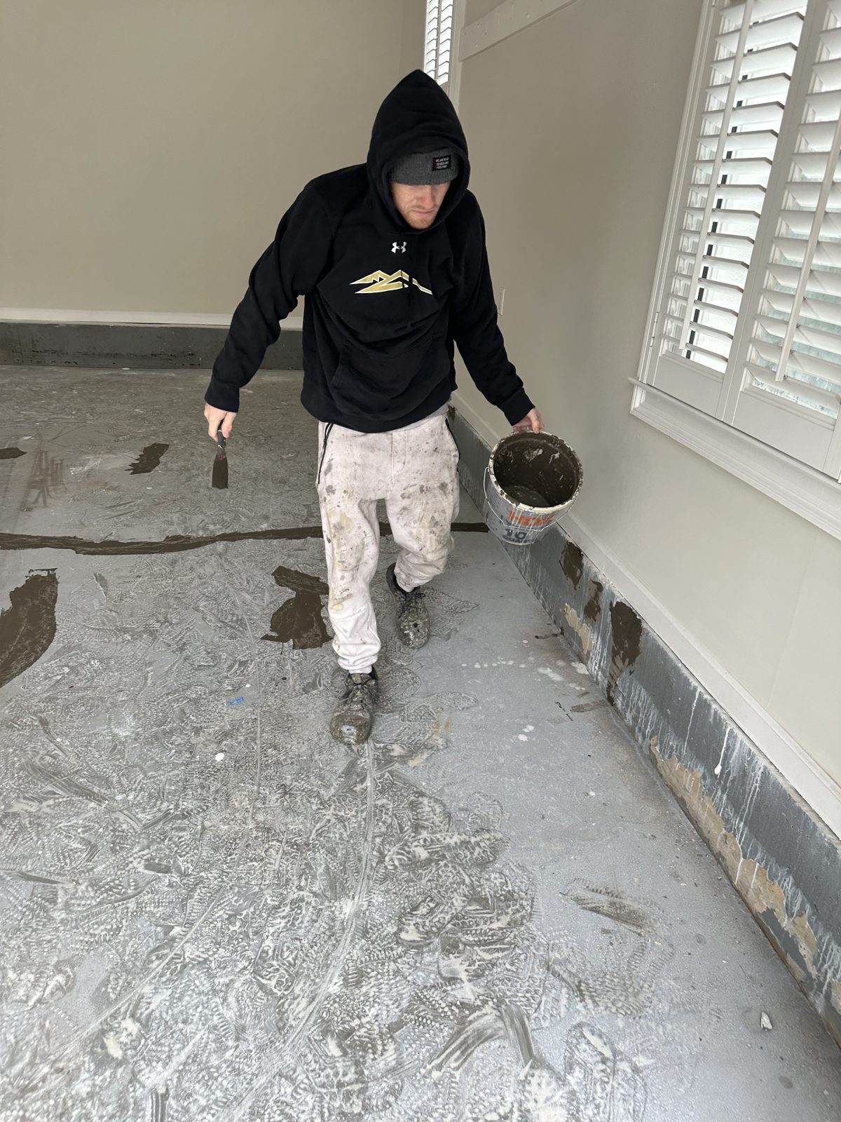 Under One Roof crew member prepping a garage floor before coating